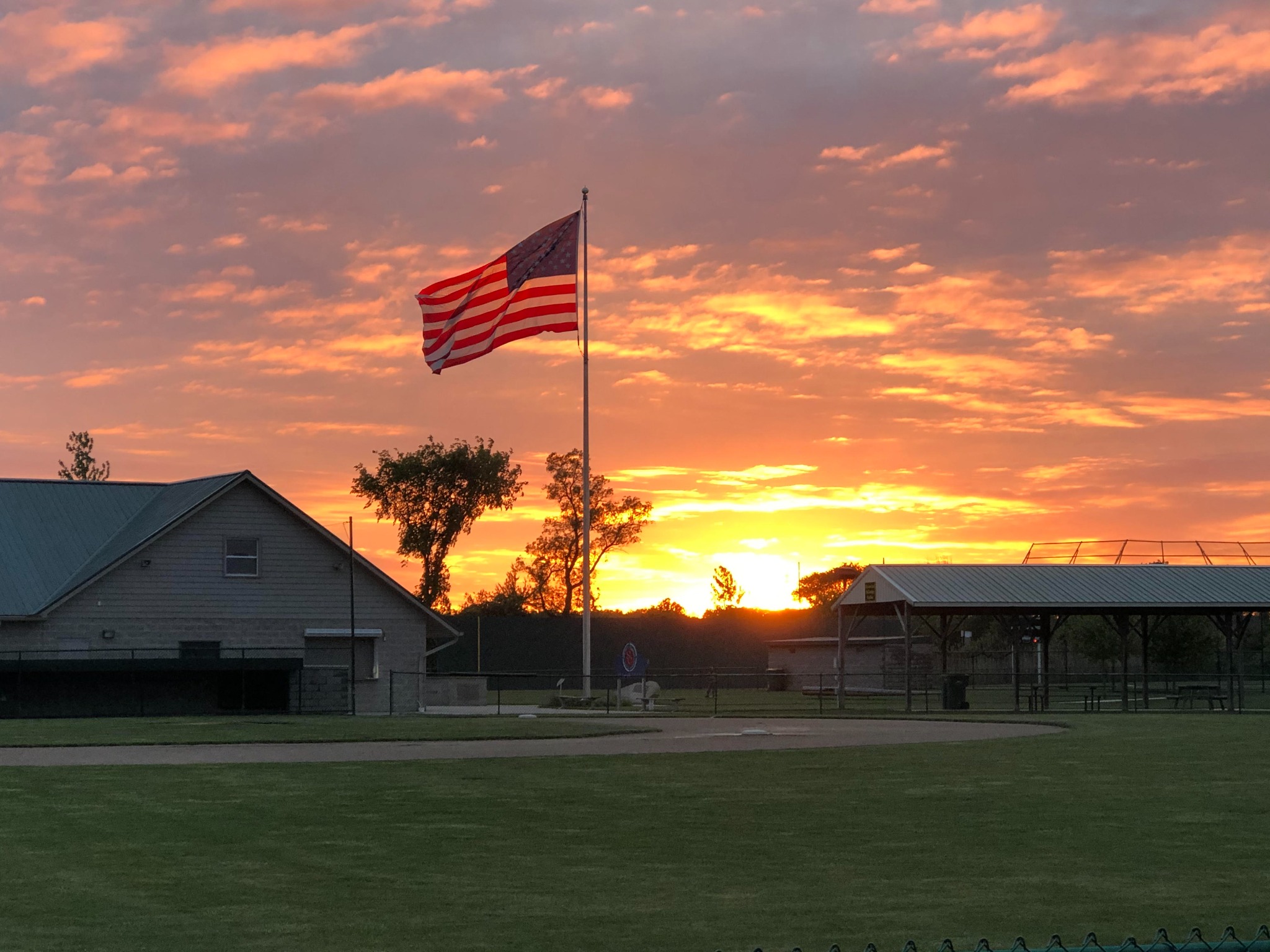 Sunset over Legacy Fields with the American flag